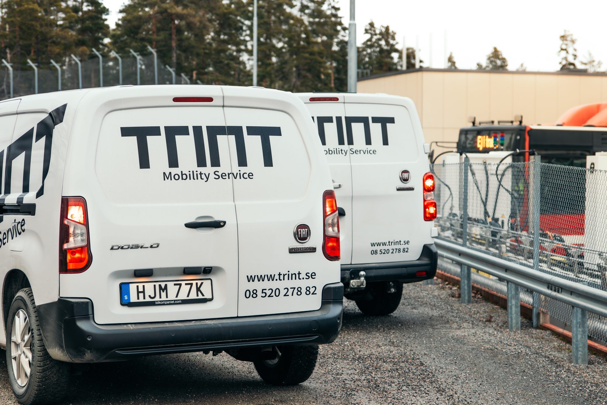 Trint service vans and an electric bus at a depot