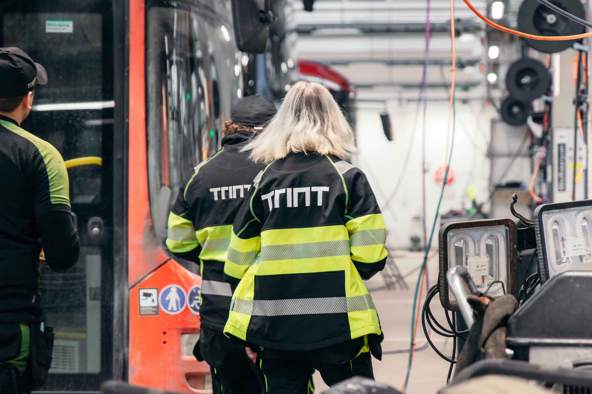 Trint-tekniker jobber med elbuss i depot
